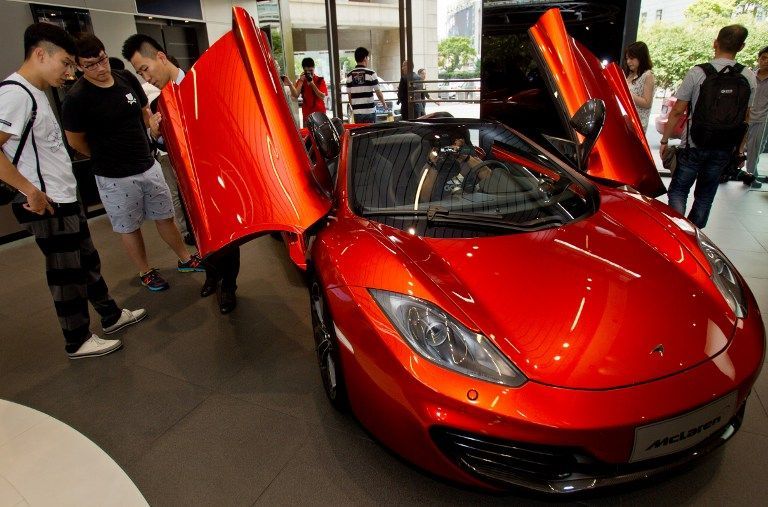 people at the first Chinese dealership unveiled by British supercar maker Mclaren Automotive on September 12, 2013 in Shanghai AFP pic