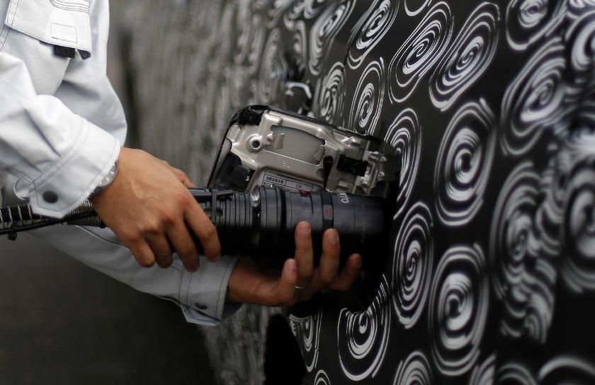 A staff member of Taiyo Nippon Sanso plugs in hydrogen nozzles to the Toyota prototype.