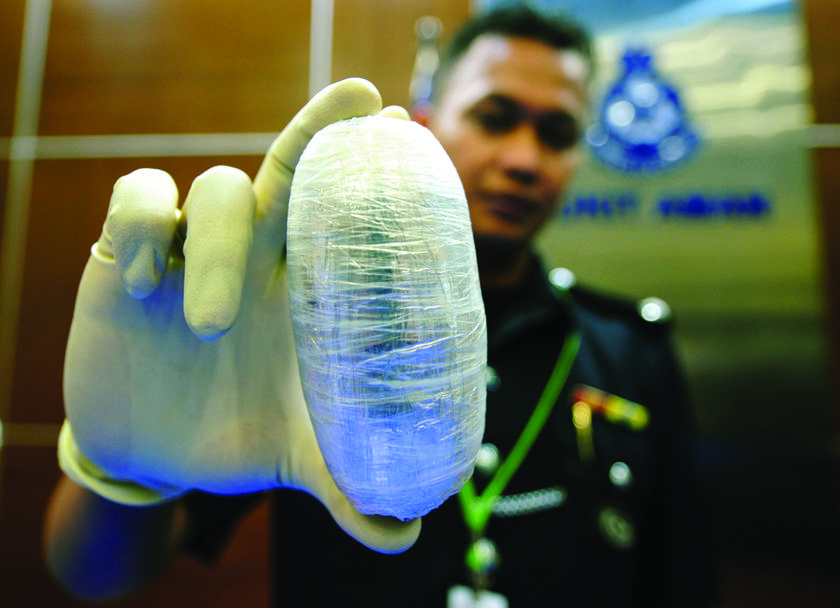 Insp Amrin Mohd Arif of the Sepang police narcotics unit showing the 350gm slab of cocaine that was recovered from the Thai woman. u00e2u20acu201d Picture by Arif Kartono 