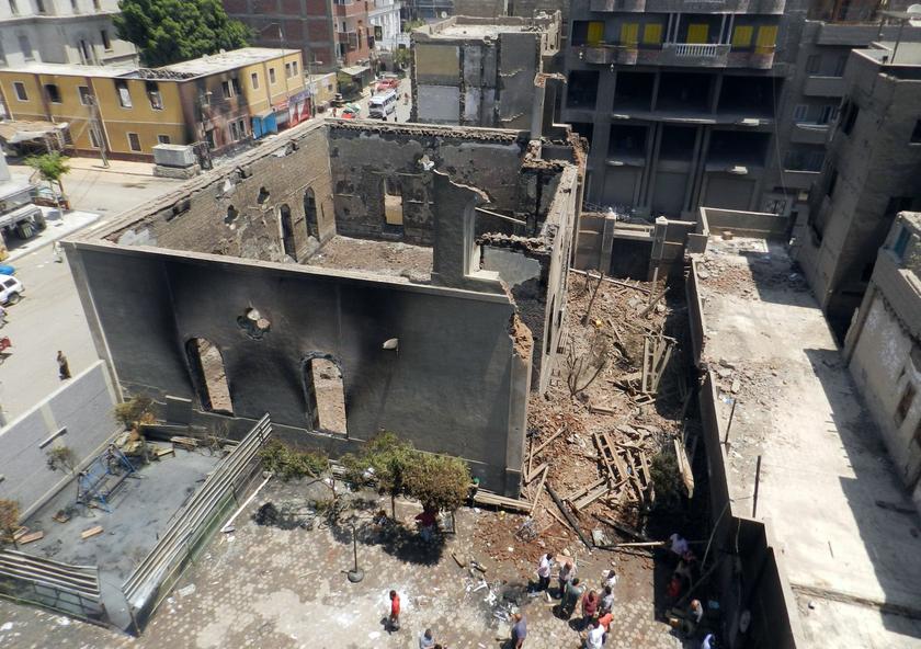 People walk around the burnt and destroyed Evangelical Church in Mallawi at Minya governorate, about 245 km (152 miles) south of Cairo August 17, 2013