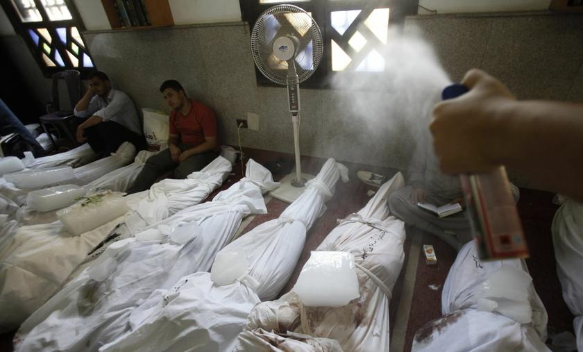 A man sprays air freshener over the bodies of the dead at El Eyman mosque in Cairo August 15, 2013, after protests in support of ousted President Mursi