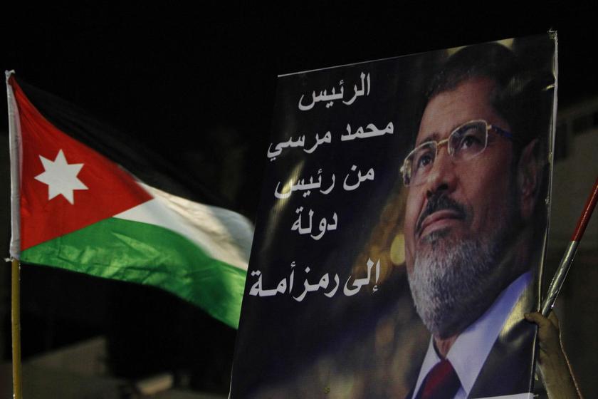 A poster of deposed president Mursi and a Jordanian national flag are held up by Islamists and members of the Egyptian community in Jordan in front of the Egyptian embassy in Amman July 26, 2013. The sign reads: “President Mursi, from head of state for national symbol”. — Reuters pic