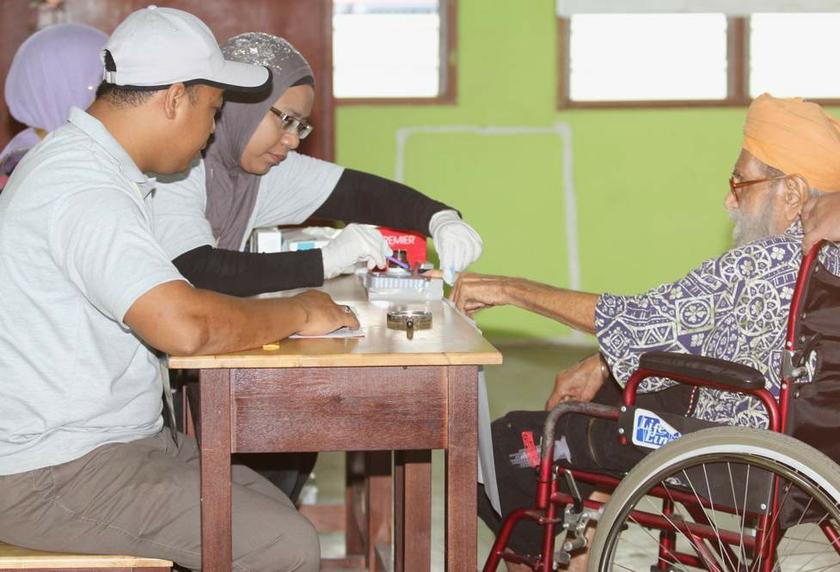 File photo of Election Commission workers inking the finger of a voter in the May 5, 2013 general election. u00e2u20acu201d Picture by Choo Choy May