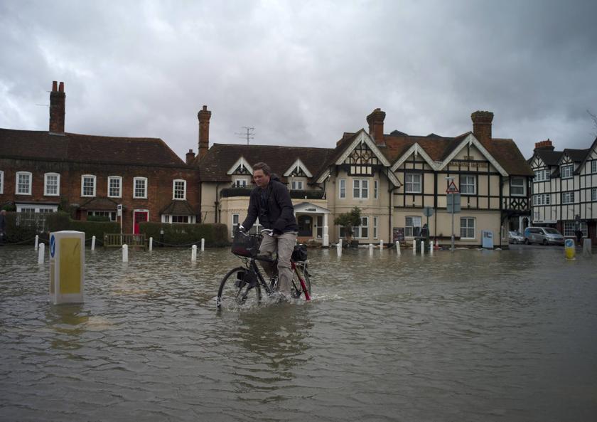 A man cycles through floodwater in the village of Datchet, southern England February 12, 2014. u00e2u20acu201d Reuters pic
