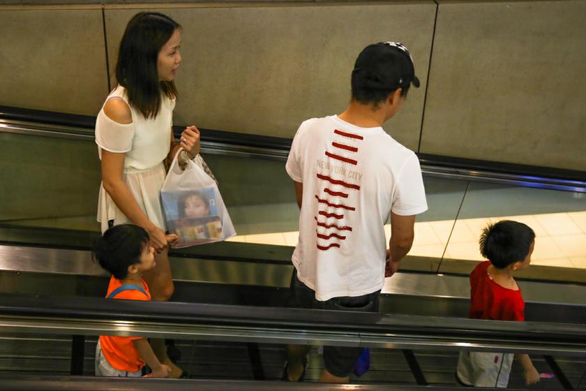 A family go down a travellator on the way to the carpark of a shopping mall in Kuala Lumpur.u00e2u20acu201d Picture by Saw Siow Feng