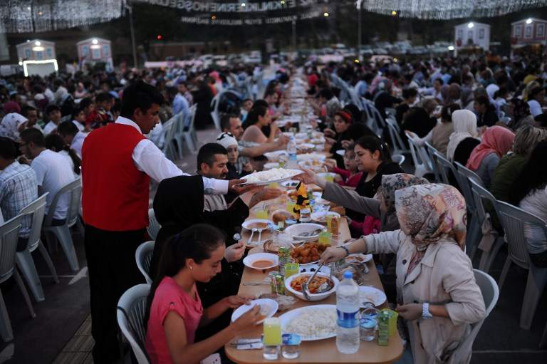 A waiter serves dinner as Turkish Muslims break their fast on July 10, 2013 in Istanbul. u00e2u20acu201d AFP pic