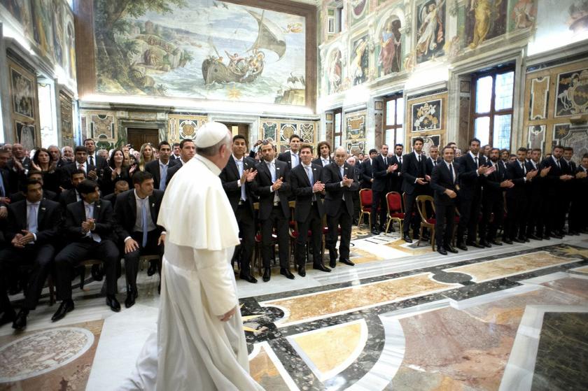 Pope Francis walks in front of members of the soccer teams of Argentina and Italy as he arrives for a private audience at the Vatican, August 13, 2013