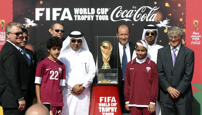 Qatar FA general secretary Saoud Al-Mohannadi (fifth left) FIFA representative Gabriel Calderon of Argentina (fourth right) and football coach Bora Milutinovic (right) pose with others next to the FIFA World Cup trophy in Doha, December 12, 2013. u00e2u20acu201d Reut