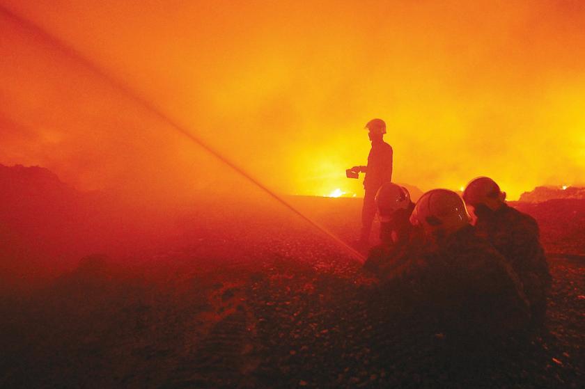 Firemen battle a blaze at the Padang Siding landfill in Perlis yesterday. 