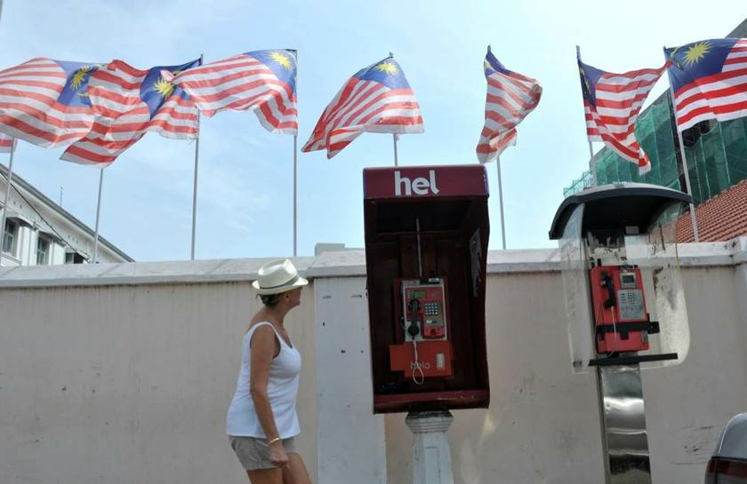 A tourist in Penang looks at the many Jalur Gemilang flying in the breeze on August 30, 2013 as Malaysia gets ready to celebrate its 56th National Day tomorrow. u00e2u20acu201d Picture by K.E. Ooi