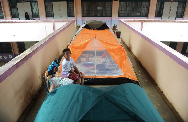  Villagers sit at a temporary shelter at a school in Kuantan,  December 4, 2013. u00e2u20acu201d AFP pic