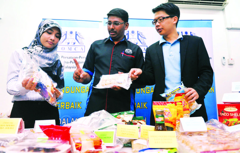Thambirajah (centre) with Fomca deputy general secretary Foon Weng Lian (right) dan legal executive Nurul Husna Mohd Yusof showing some of the expired products. 