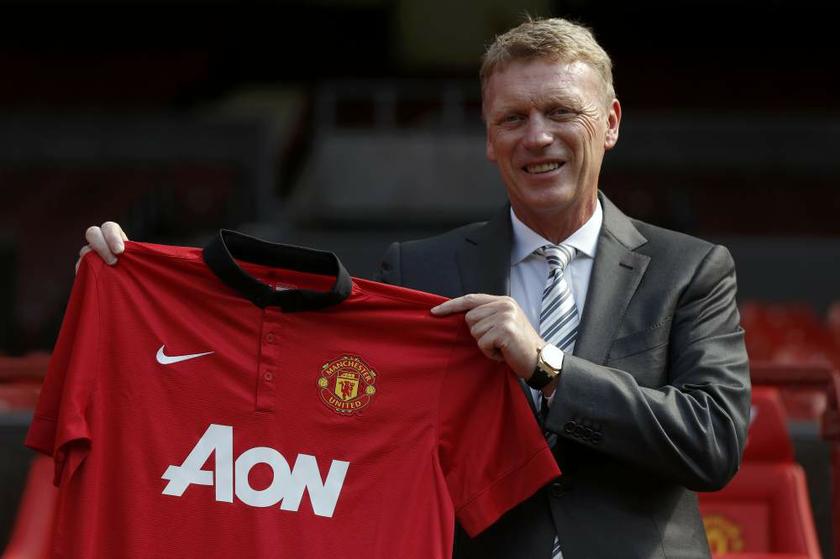 New Manchester United manager David Moyes poses with a football shirt in front of the home team dugout before a news conference at Old Trafford in Manchester on July 5, 2013. u00e2u20acu201d Reuters pic