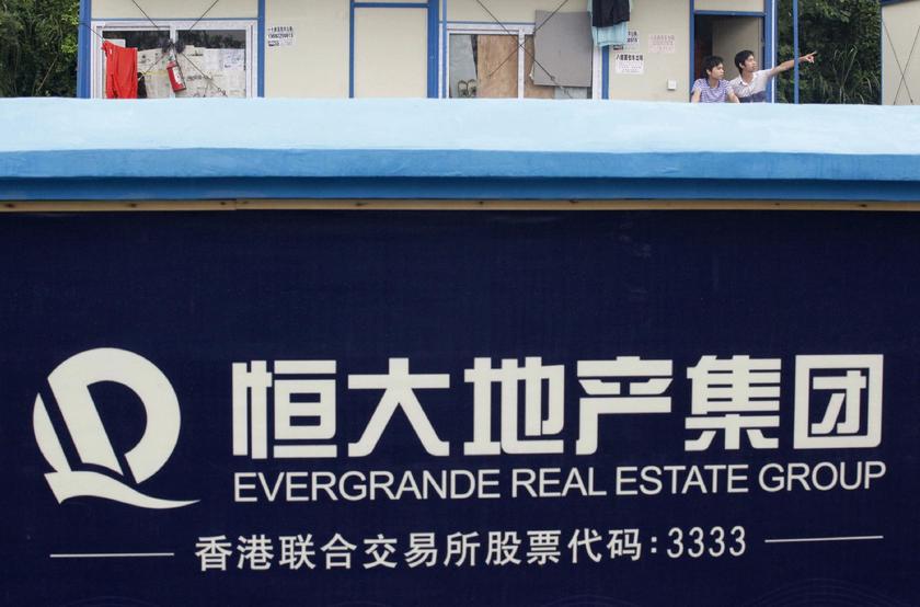 A labourer (R) gestures to his colleague outside their dormitory at a residential construction site of Evergrande, one of the biggest Chinese developers, in Guangzhou, Guangdong province, June 22, 2012 Reuters pic