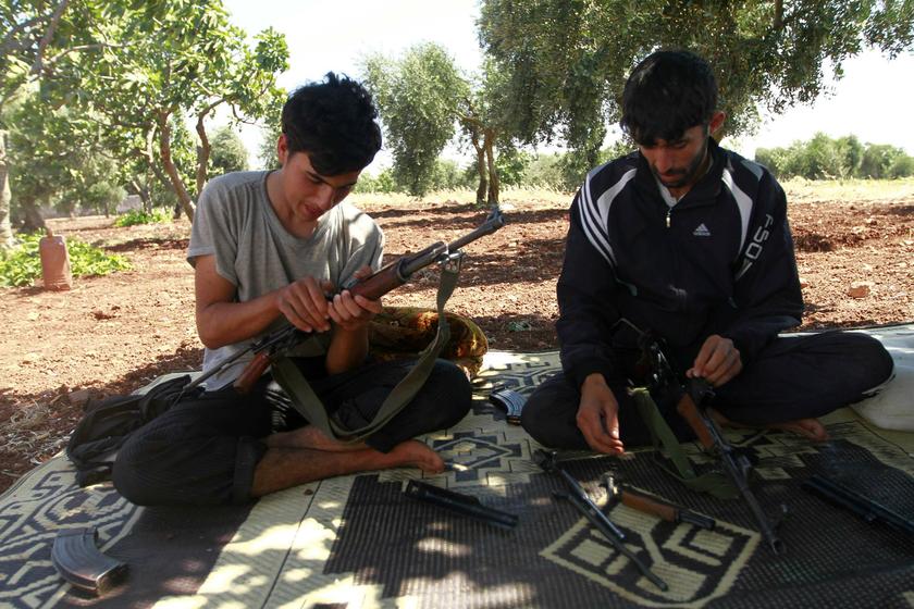 Free Syrian Army members inspect their weapons while resting in an orchard beside a checkpoint during a siege on the Kurdish city of Afrin, which is under the control of the Kurdistan Workers' Party, in the Aleppo countryside June 30, 2013. u00e2u20acu201d Reuters pi