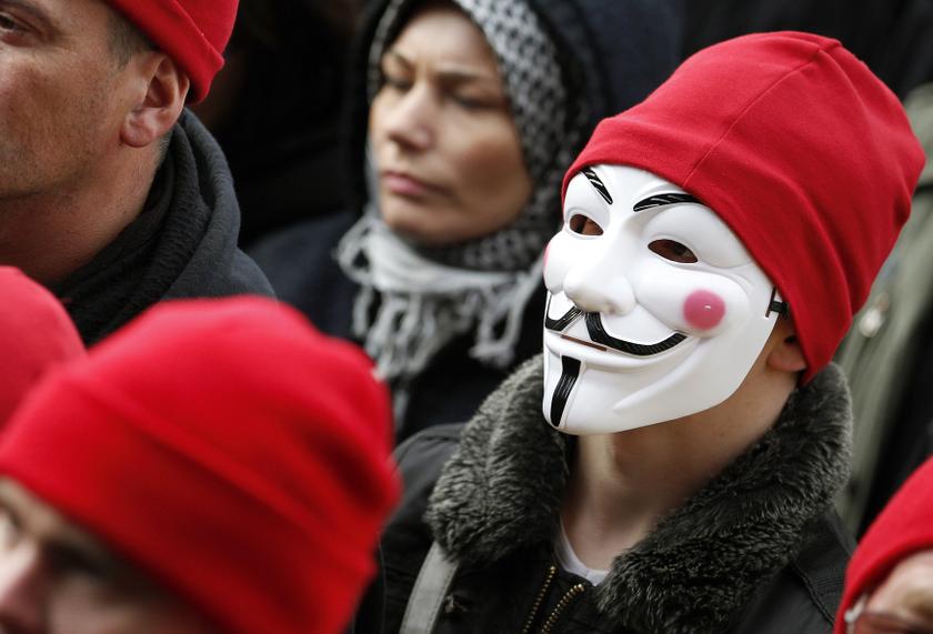 A protester wearing a red cap, the symbol of protest in Brittany, and a Guy Fawkes mask takes part in a demonstration to maintain jobs in the region and against an 'ecotax' on commercial trucks, in Carhaix, France, November 30, 2013. u00e2u20acu201d Reuters pic