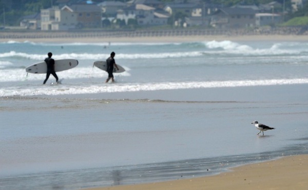 Local people walk out of the sea with surf boards on Toyoma Beach, some 50 kilometres south of the broken Fukushima nuclear power plant, in Iwaki, Fukushima prefecture, on August 24, 2013. u00e2u20acu201d AFP pic