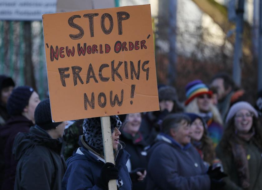 A demonstrator holds a placard in front of a police cordon outside the entrance to the IGas Energy exploratory gas drilling site at Barton Moss near Manchester in northern England January 13, 2014. u00e2u20acu201d Reuters pic
