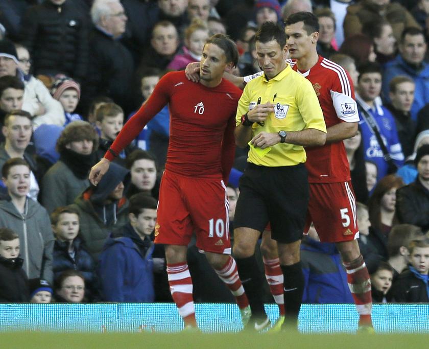 Southampton's Gaston Ramirez (left) is booked by referee Mark Clattenburg (right) after celebrating scoring a goal against Everton by giving his shirt away to a fan during their English Premier League match at Goodison Park in Liverpool, December 29, 2013