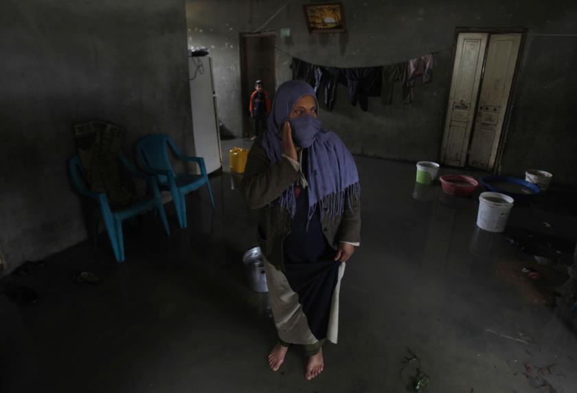 A Palestinian woman stands in her house on a stormy day in Khan Younis in the southern Gaza Strip December 14, 2013. u00e2u20acu201d Reuters pic