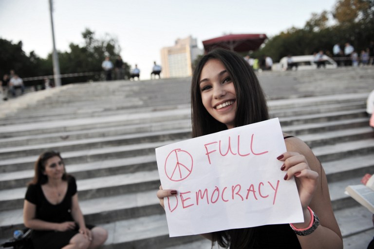 A woman holds a placard while standing at the enterance of Gezi Park in Istanbul on June 19, 2013, during a wave of new alternative passive protests. u00e2u20acu201c AFP pic