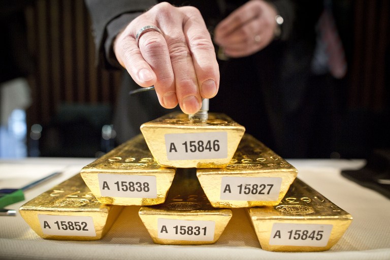 An employee of the German Federal Bank checks the core of a bar of gold during a press conference at the German Federal Bank in Frankfurt am Main, western Germany, January 16, 2013. - AFP pic