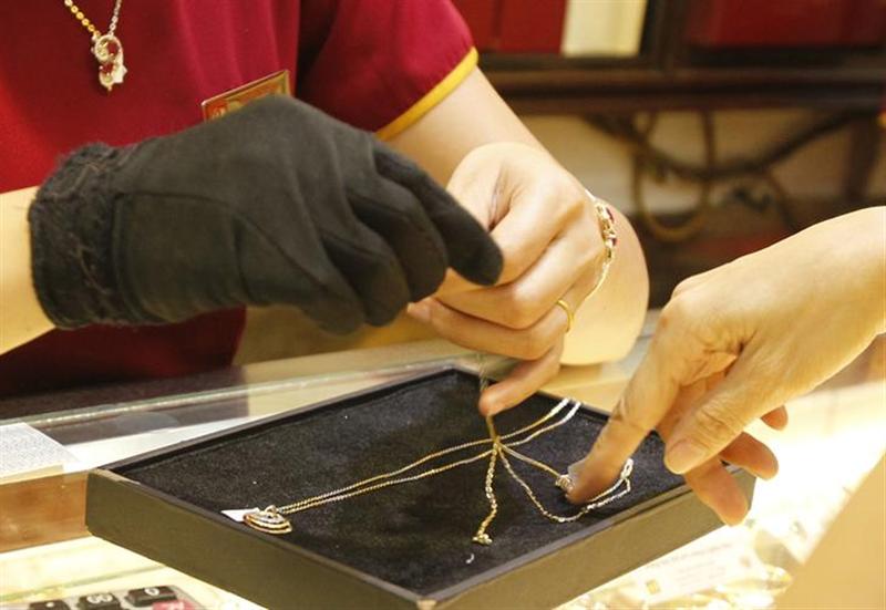 An employee shows gold products to a client at a shop in Hanoi June 11, 2013. u00e2u20acu201c Reuters pic