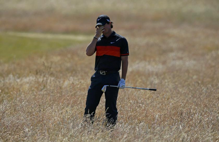 Rory McIlroy of Northern Ireland reacts after playing a shot from the rough on the third hole during the second round of the British Open golf championship at Muirfield in Scotland July 19, 2013