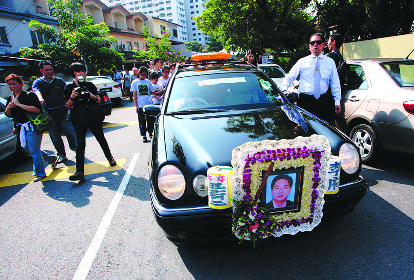 Relatives and family friends and officers from the Sentul police headquarters at Leeu00e2u20acu2122s funeral. 