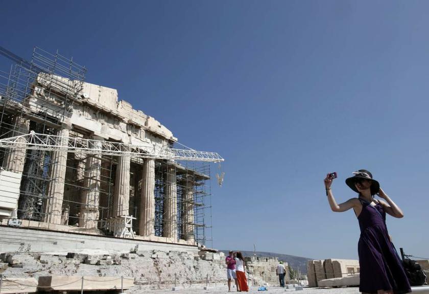 A tourist takes pictures in front of the Parthenon temple at the Acropolis hill in Athens on August 19, 2013. u00e2u20acu201d Reuters pic