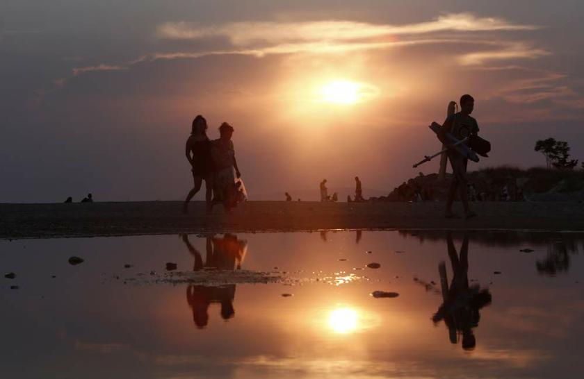 People leave a beach at the Glyfada suburb, south of Athens, on August 25, 2013. Spending by tourists in Greece surged in June, central bank data showed. u00e2u20acu201d Reuters pic