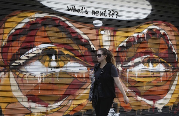 A woman walks in front of a graffiti painted on a shop shutter, in Athens September 2, 2013. u00e2u20acu201d Reuters pic