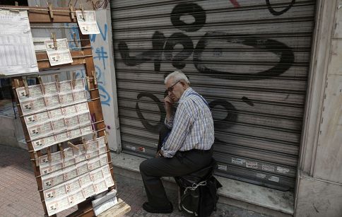 A lottery ticket vendor sits outside of a closed shop in central Athens June 28, 2013. u00e2u20acu201d Reuters pic