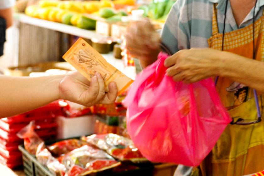 A customer pays for some tidbits at a local wet market in Kuala Lumpur.u00e2u20acu201d Picture by Saw Siow Feng