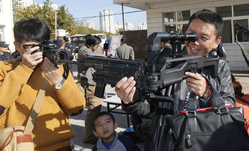 A man plays with an unloaded gun as he is being photographed during a Special Weapons and Tactics (SWAT) open day in Qingdao, Shandong province, November 7, 2013. u00e2u20acu201du00c2u00a0Reuters pic