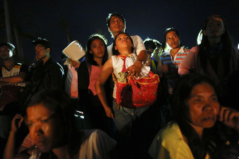 A man hugs a girl as hundreds of desperate typhoon survivors hoping to catch a flight gather at the Tacloban airport late November 14, 2013. u00e2u20acu201d Reuters pic