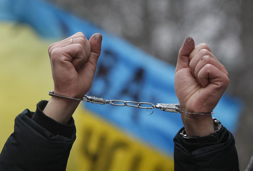 A Pro-European integration supporter holds up handcuffs during a rally against newly approved laws near the presidential administration in Kiev January 17, 2014. u00e2u20acu201d Reuters pic