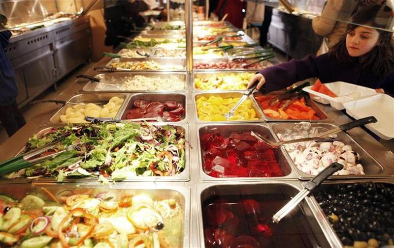 A girl helps herself to a buffet at a fast food restaurant in Harlem in New York December 16, 2009. u00e2u20acu201c Reuters pic