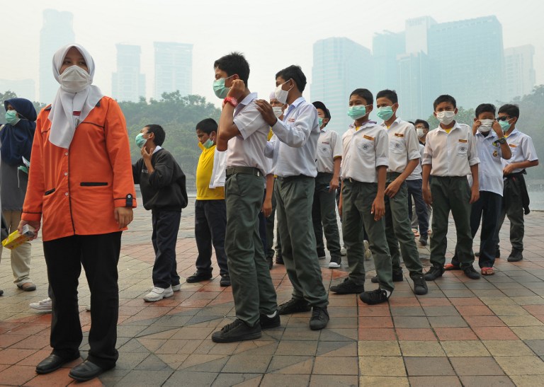 Students wear masks as haze shrouds Kuala Lumpur on June 23, 2013. u00e2u20acu201c AFP pic
