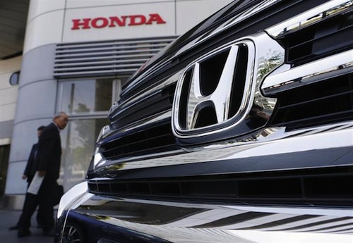 Visitors look at a Honda Motor Cou00e2u20acu2122s car displayed outside the company showroom in Tokyo April 26, 2013. u00e2u20acu201d Reuters pic
