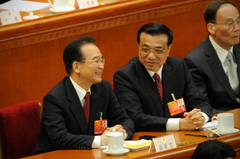 Chinese Premier Wen Jiabao (L) shares a light moment with Vice Premier Li Keqiang during the opening session of the Chinese National People's Congress (NPC) at the Great Hall of the People in Beijing on March 5, 2013.