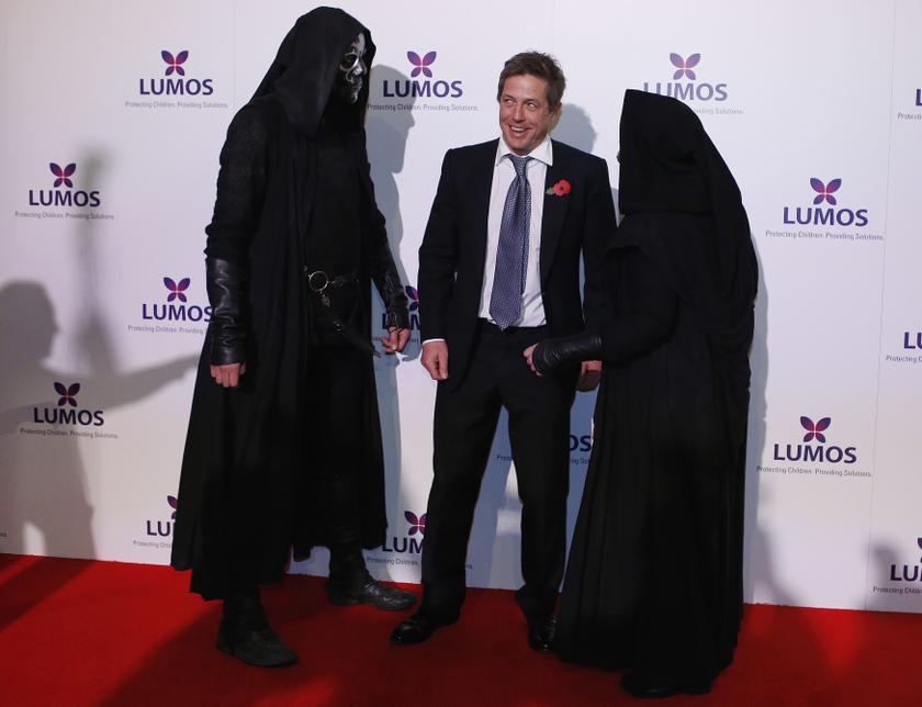 Actor Hugh Grant poses for a picture with men dressed as the characters u00e2u20acu02dcDeath Eatersu00e2u20acu2122, before a special family fundraising evening hosted by author J.K. Rowling at the u00e2u20acu02dcWarner Bros. Studio u00e2u20acu201d The Making of Harry Potter in Hertfordfshireu00e2u20acu2122 in Lond