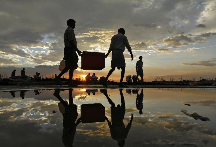 Fishermen carry a box filled with fish at a fishing harbour in the southern Indian city of Chennai on August 30, 2013. u00e2u20acu201d Reuters pic