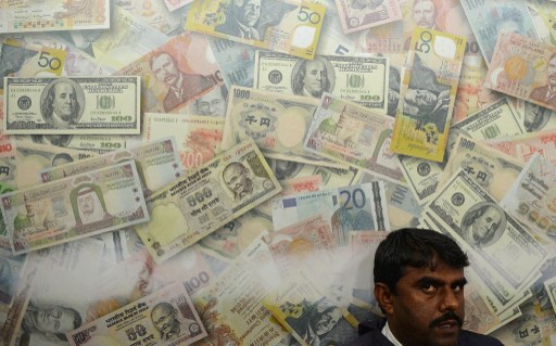 An Indian man looks on at a local currency exchange shop in Mumbai on June 26, 2013. u00e2u20acu201d AFP pic