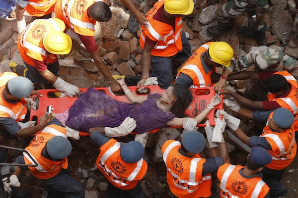 Rescue workers use a stretcher to carry a victim across the rubble after the collapse of two residential buildings in Vadodra city, located in the western Indian state of Gujarat August 28, 2013. At least seven people are reported to have been killed. u00e2u20acu201d