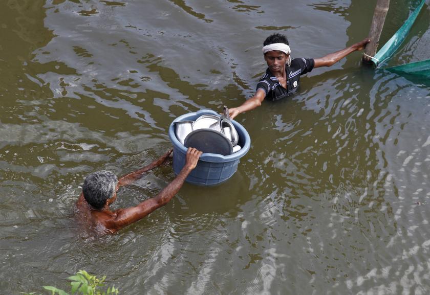Men transport a bucket filled with kitchen equipment, after heavy monsoon rains caused a rise in the water levels of the river Ganges, in the northern Indian city of Allahabad. u00e2u20acu201c Reuters pic