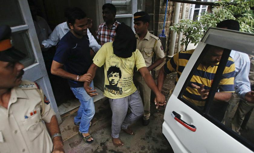 Police officers escort a man (face covered), arrested in connection with the gang-rape of the photo journalist, at a court in Mumbai August 25, 2013. — Reuters pic