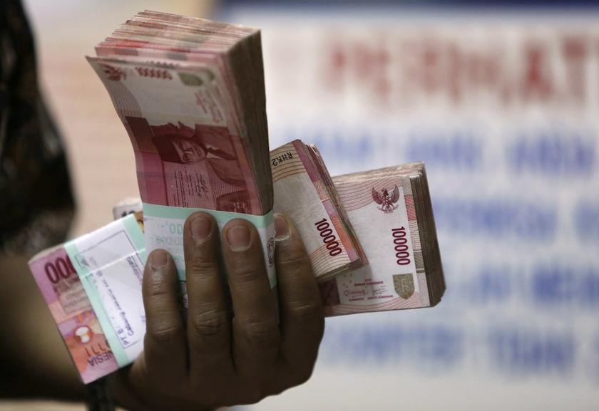 A moneychanger holds stacks of Indonesian rupiah notes in Jakarta, August 29, 2013. u00e2u20acu201d Reuters pic