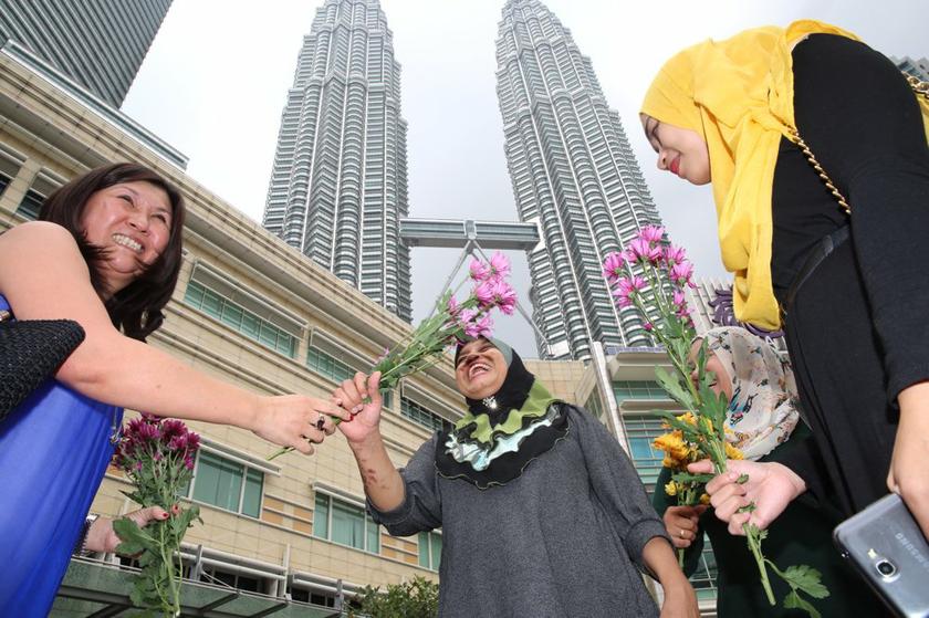 Malaysians gather at a city park in Kuala Lumpur to gift passers-by flowers, chocolates and balloons on January 26, 2013 to promote interfaith harmony.u00e2u20acu201d Picture by Choo Choy May