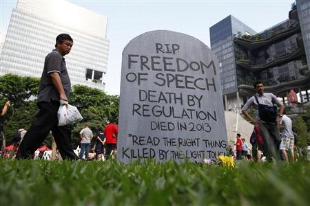 Protesters walk past a mock gravestone that reads u00e2u20acu02dc'RIP Freedom of Speechu00e2u20acu2122 during a protest against new licensing regulations imposed by the government for online news sites, at Hong Lim Park in Singapore on June 8, 2013. u00e2u20acu201d Reuters pic